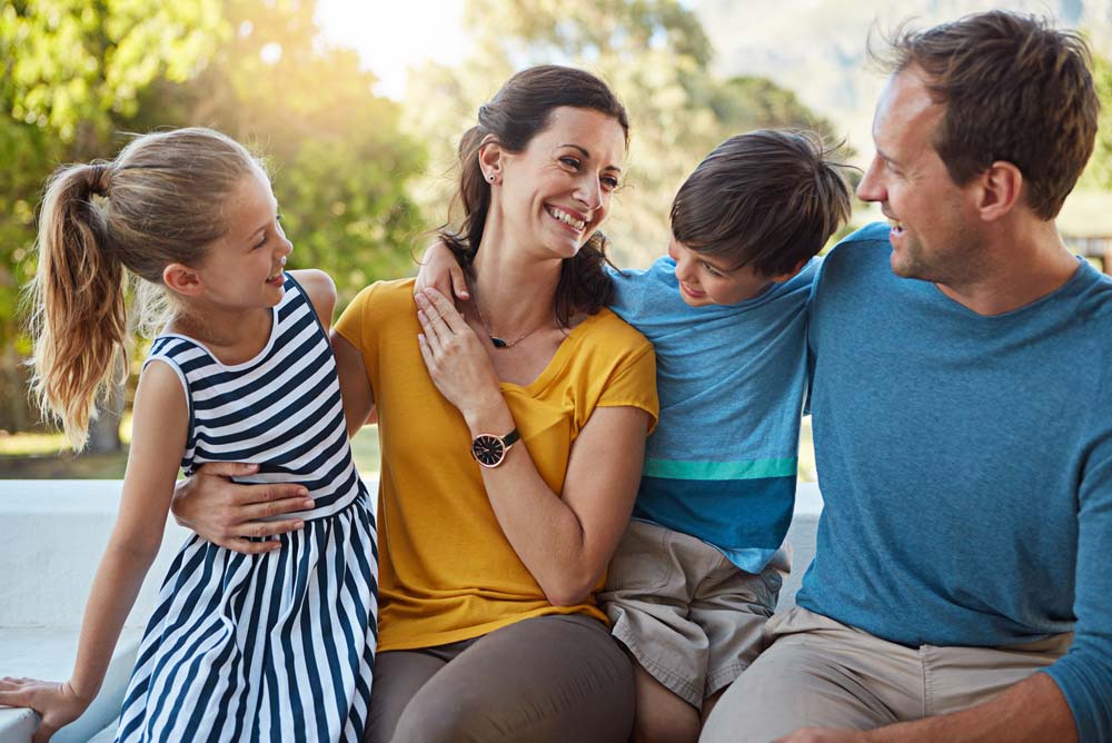 Family smiling together after Complex Crown and Bridges Restorations dental treatment at Griffith Dental